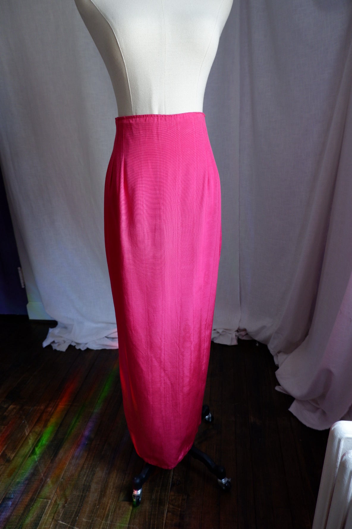 Angled view of hot pink moiré column skirt showing watered sheen