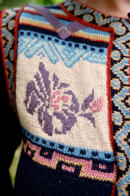 Detail of the lilac floral intarsia and geometric border on a John Ashpool knit