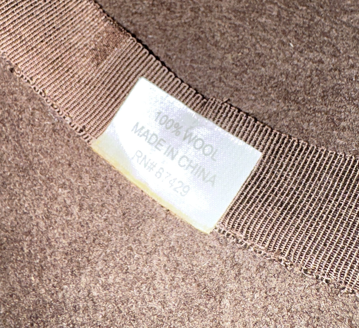 100% wool label inside a brown felt hat with grosgrain band