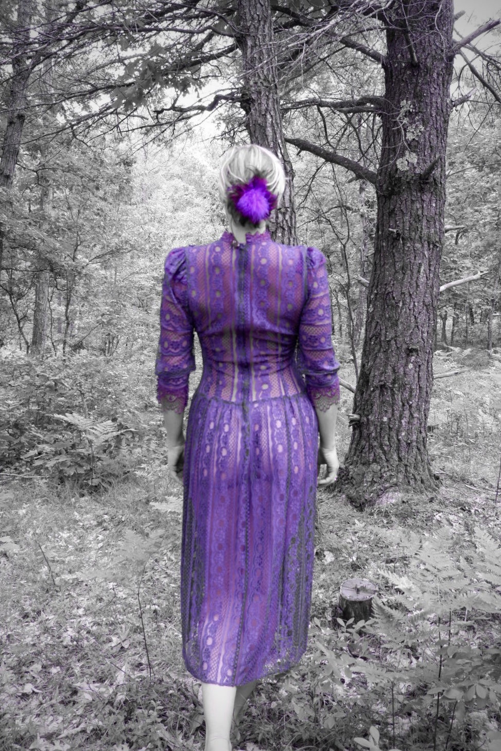 Back view of a plum lace maxi dress with puff shoulders in a forest (artistic color edit)