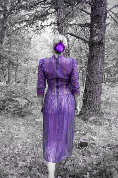 Back view of a plum lace maxi dress with puff shoulders in a forest (artistic color edit)
