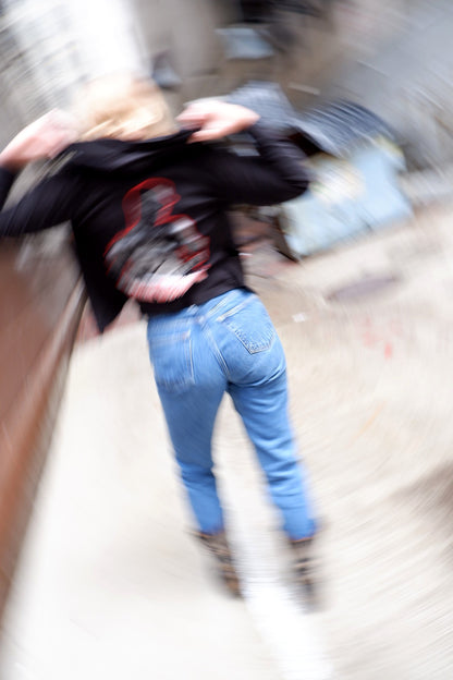 Motion-blur editorial shot of a Social Distortion hoodie with vintage jeans
