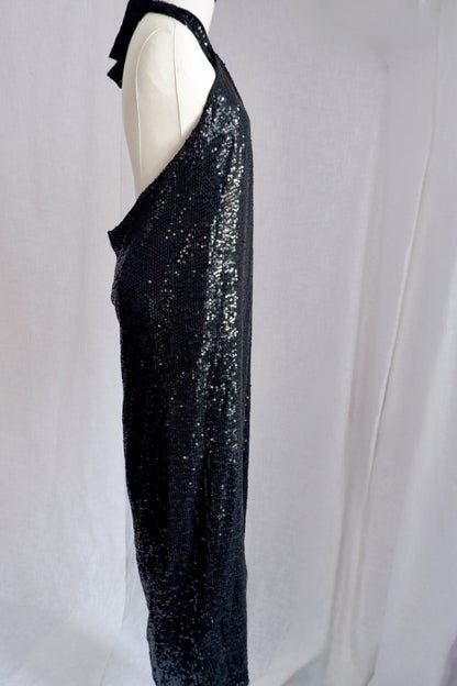 Side view of Donna Karan black sequin halter gown showing open back and column skirt