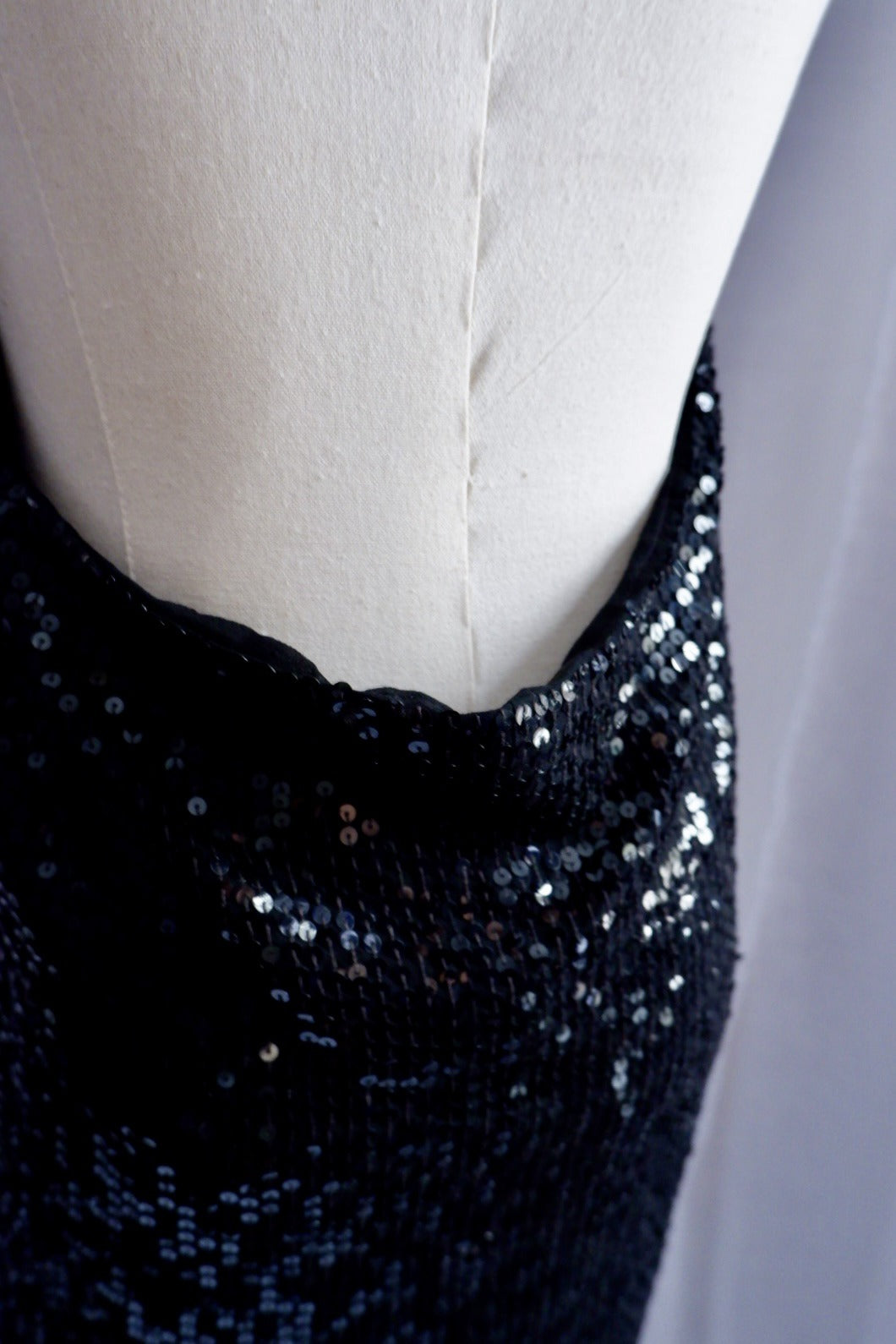 Low back edge of Donna Karan black sequin gown, close-up