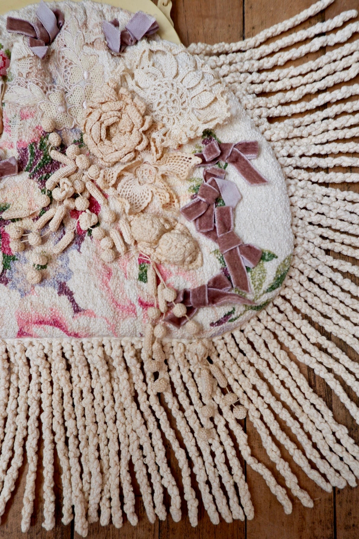 Close-up of crochet rose, lace, velvet bows and cream fringe