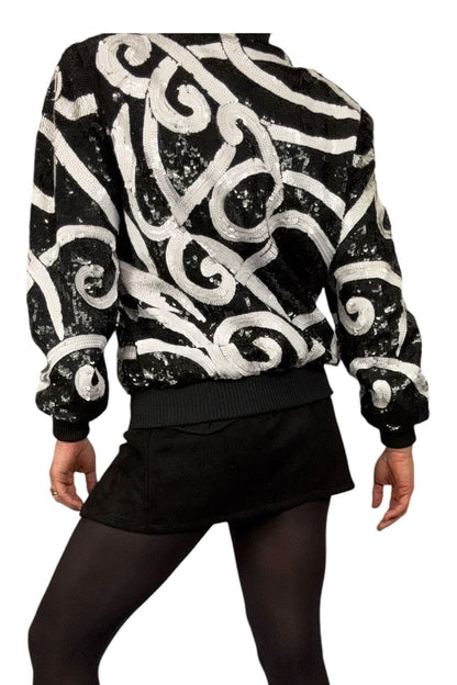 Back view of vintage Laurence Kazar sequin bomber jacket showing white swirl pattern across the back and sleeves