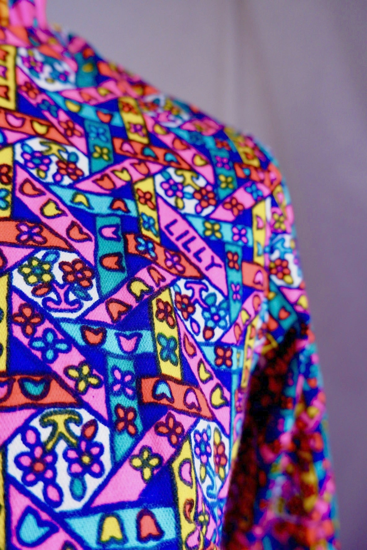 Shoulder detail of colorful stained-glass print with LILLY signature on vintage dress