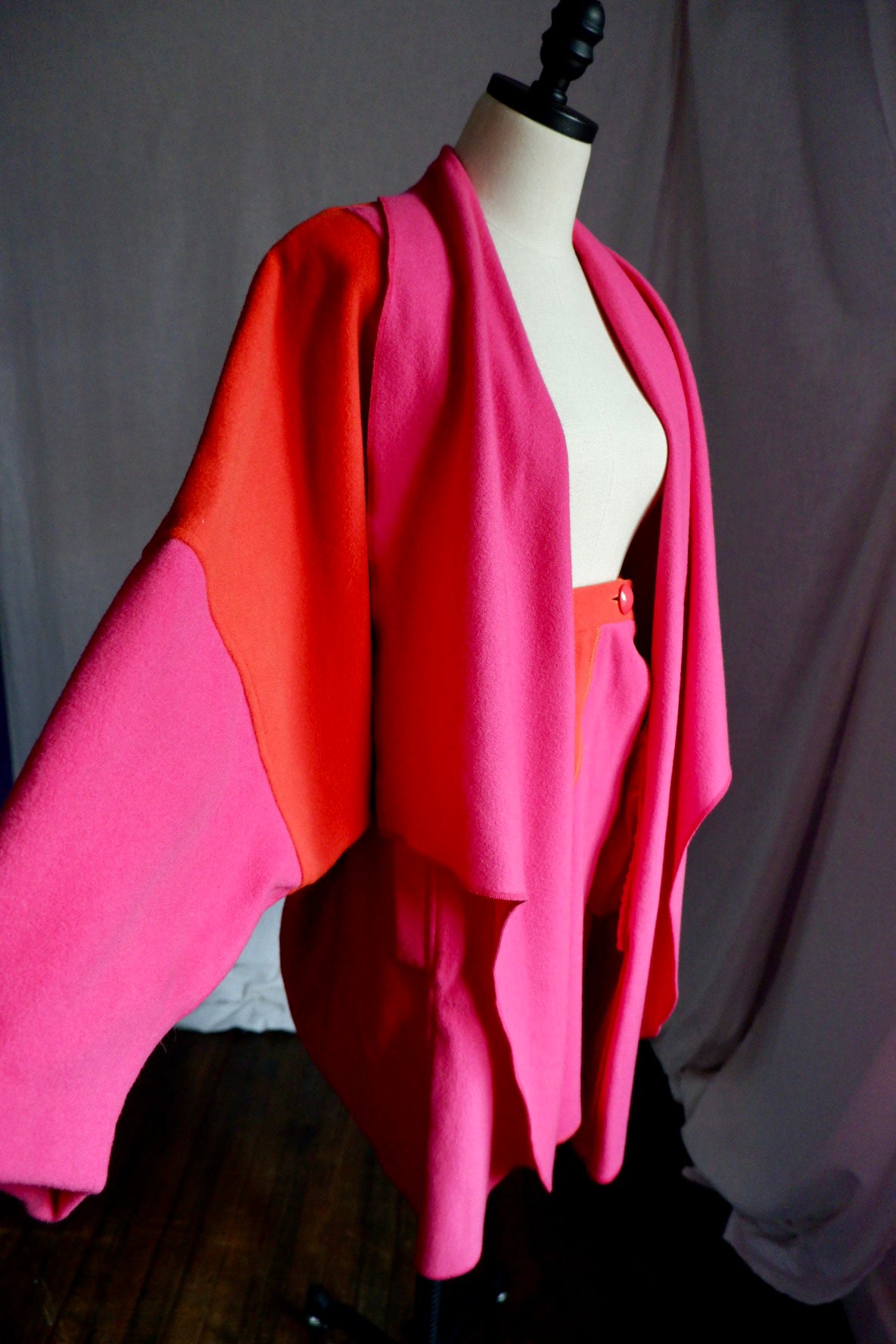 Merle Chicago wool coat with dolman sleeve extended showing orange and pink color blocking