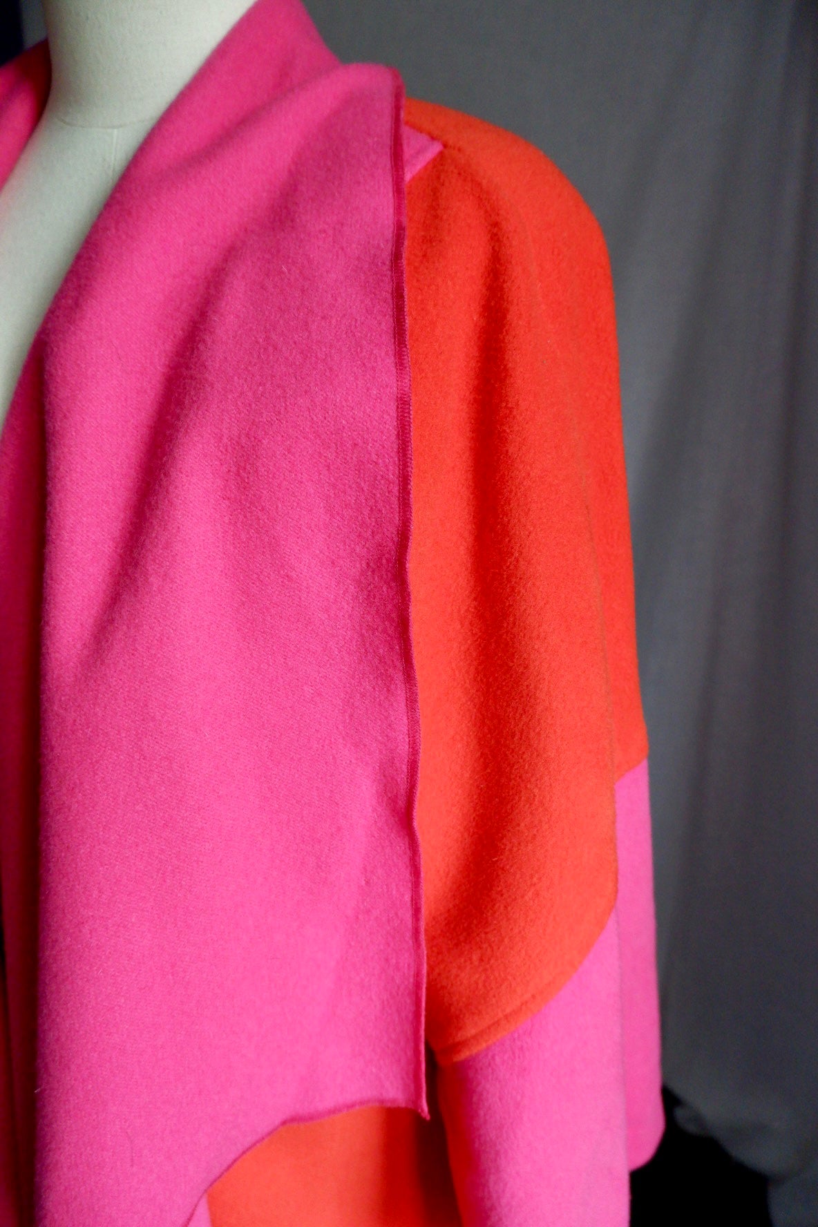 Detail of raw-edge pink shawl collar against orange shoulder of Merle Chicago wool coat