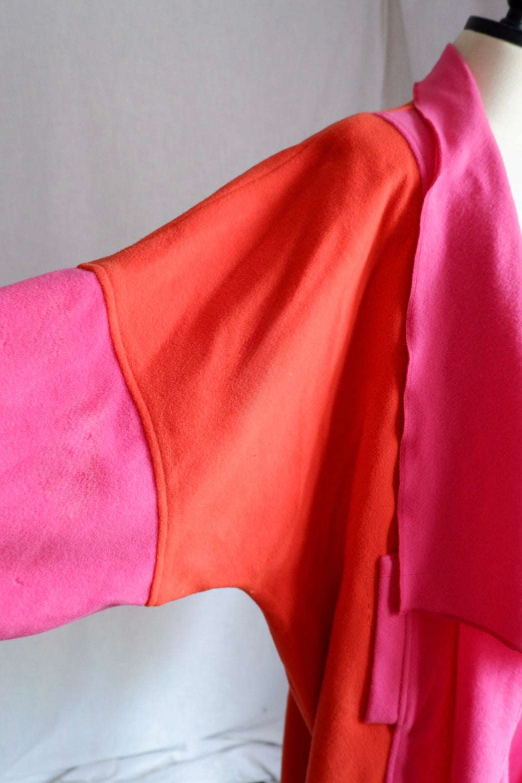 Close-up of orange shoulder and pink sleeve seam on Merle Chicago wool coat