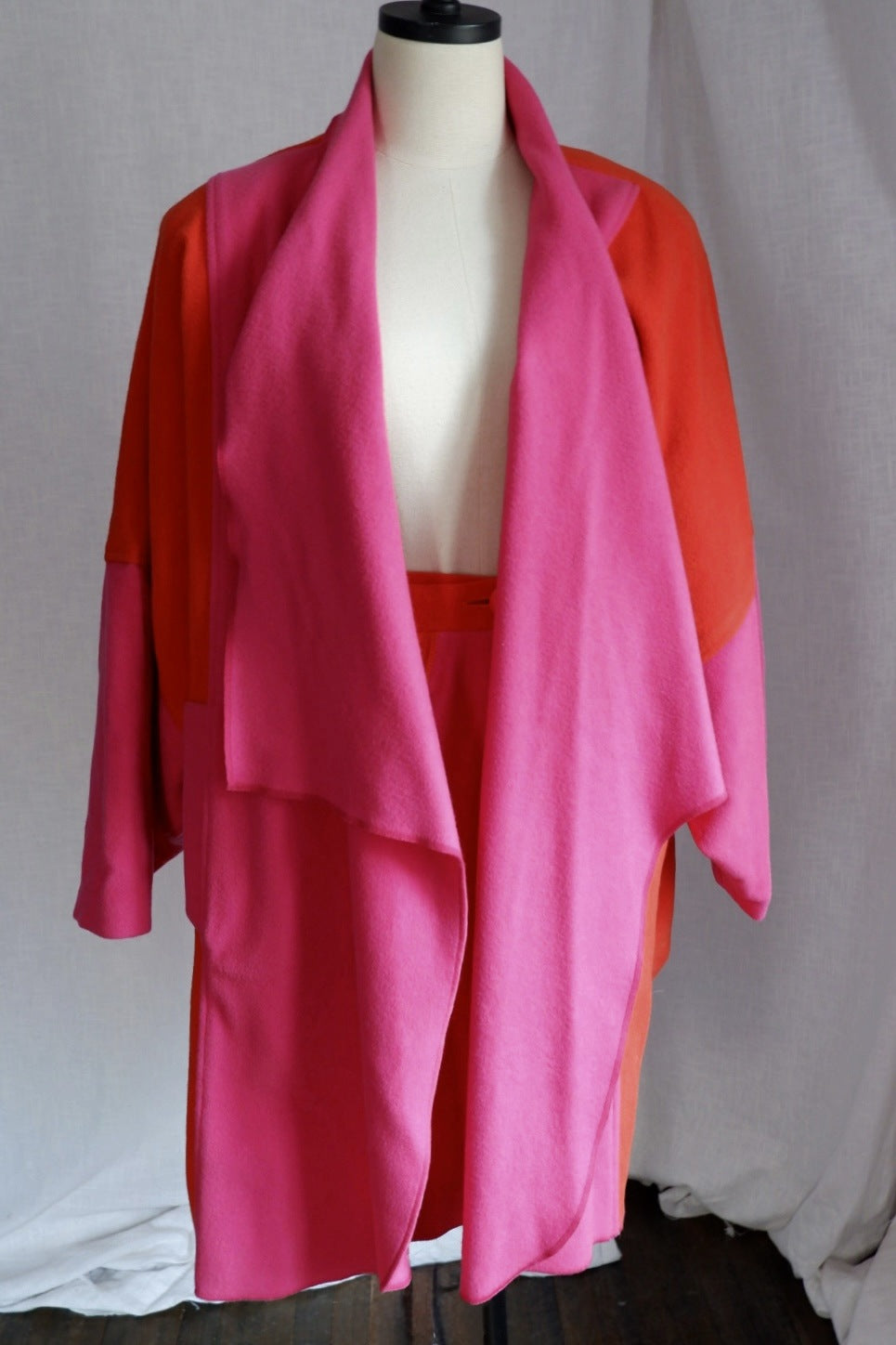 1980s Merle Chicago hot pink and orange wool draped coat and skirt set on a dress form, front view