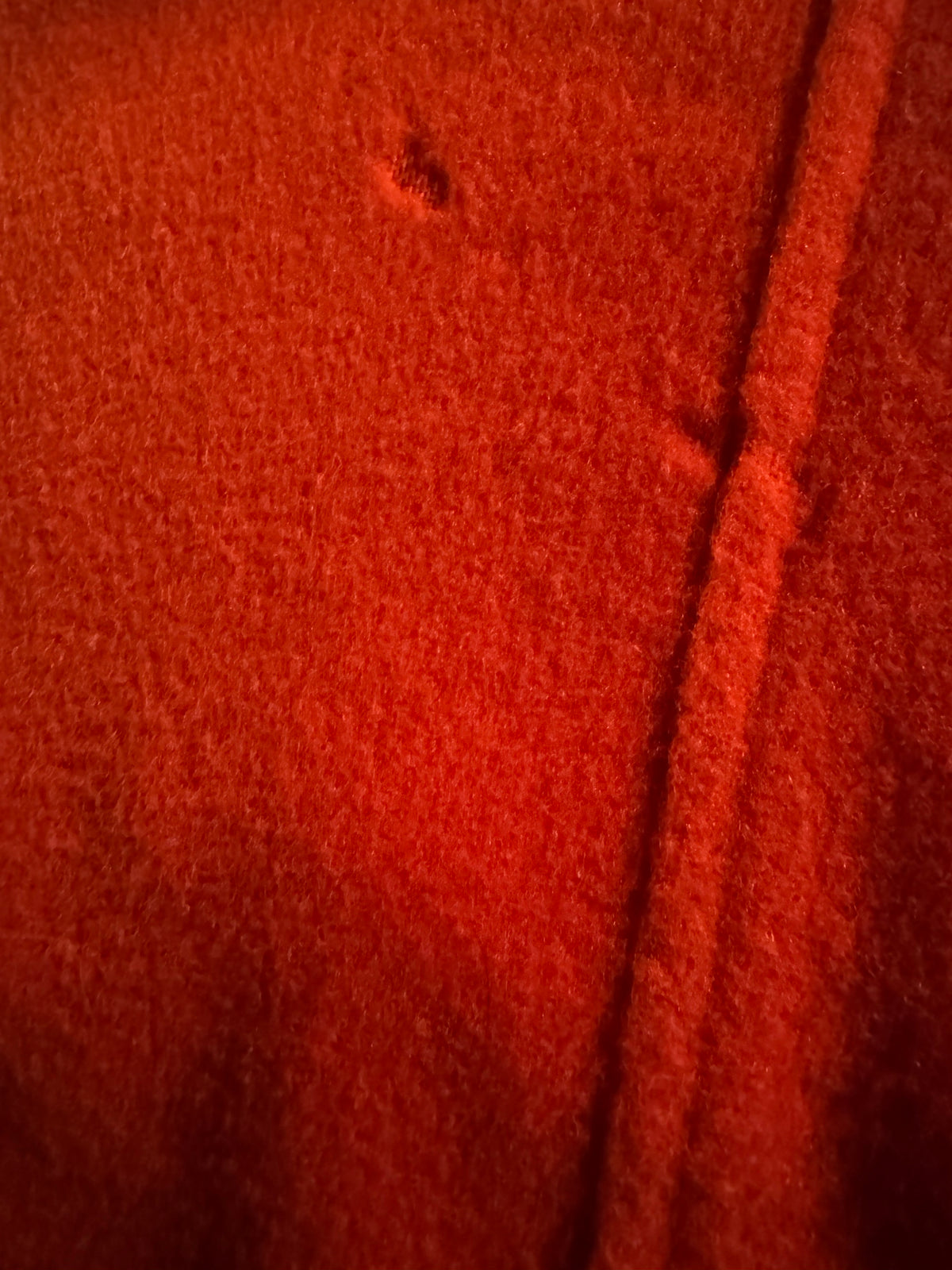 Close-up of small area of moth grazing on the orange wool back of the Merle Chicago coat, no hole