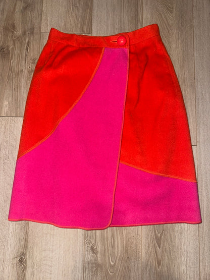 Merle Chicago orange and hot pink wool wrap skirt laid flat, showing curved color-block panels and button waist