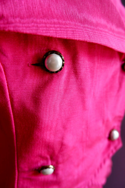 Close-up of pearl buttons in rope-twist metal settings on hot pink moiré jacket