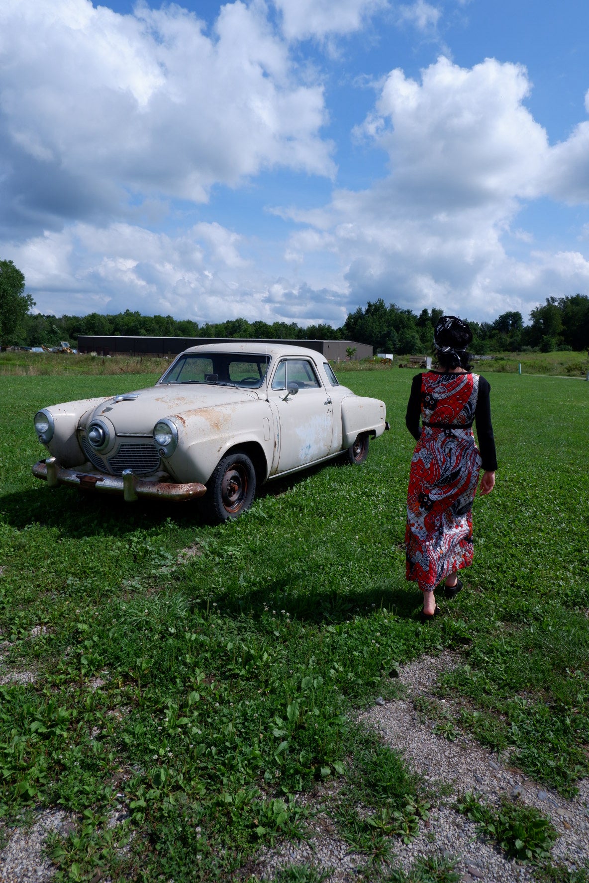 Quilted maxi dress walking toward a vintage car in a field