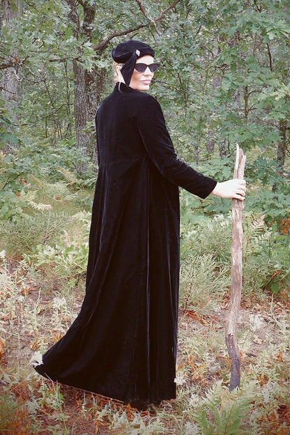 1960s black velvet opera coat worn in the woods, looking over the shoulder