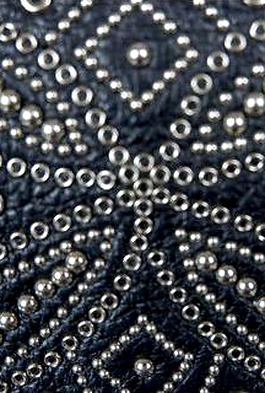 Close-up of the silver stud starburst on a vintage Gianni Versace black leather clutch