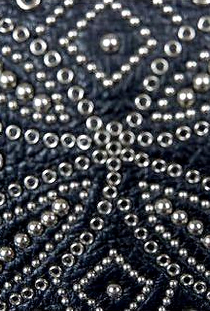 Close-up of the silver stud starburst on a vintage Gianni Versace black leather clutch