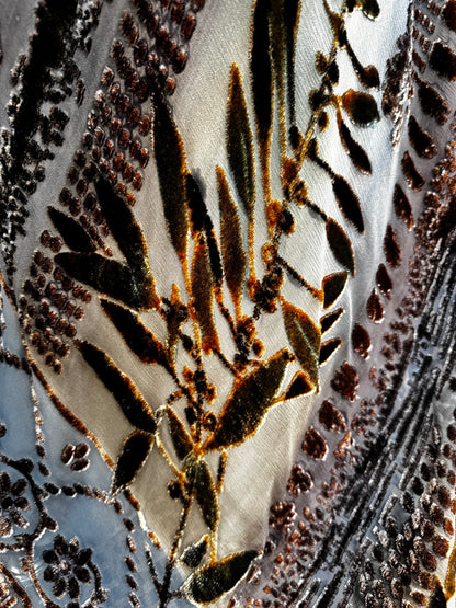 Close-up of Zonda Nellis silk burnout velvet with bronze and olive leaves on sheer slate blue ground